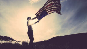 A person waves an American Flag