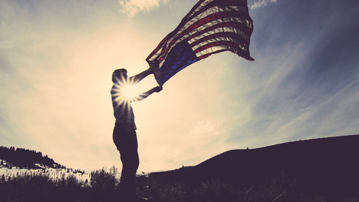 A person waves an American Flag