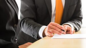 An insurance professional instructs their client how to fill out paperwork.