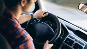 A young adult drives a car.