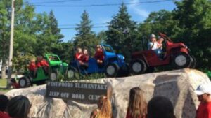 Michigan Planners members ride miniature Jeeps at the Traverse City Cherry Festival.