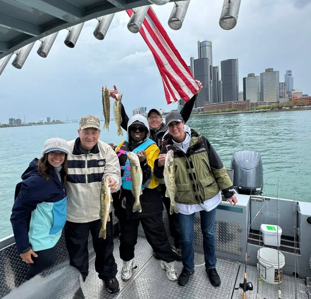 The Michigan Planners team poses on a boat during the team fishing trip. Several members show off their catches.