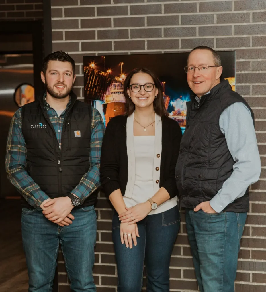 Three family members on the Michigan Planners team smile together.