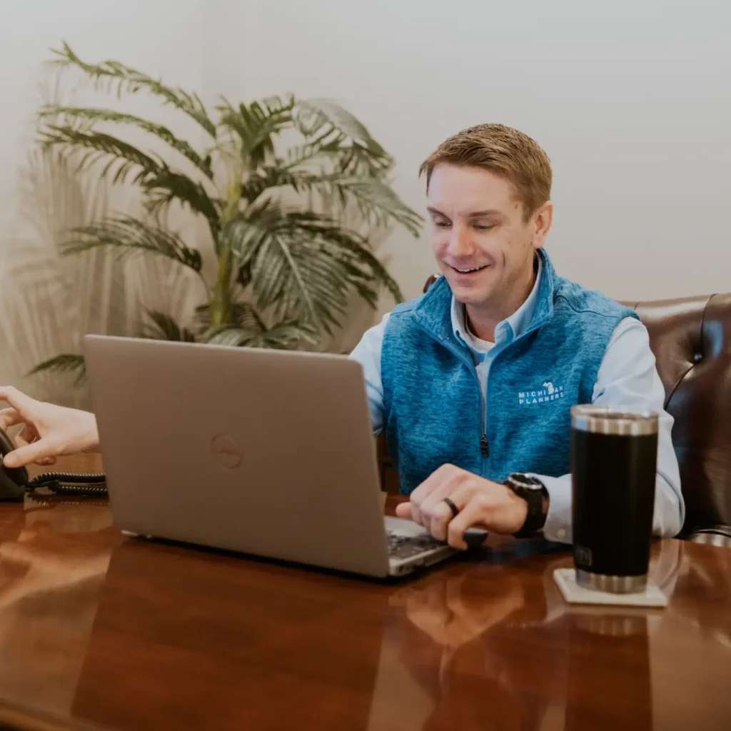 A Michigan Planners team member speaks on a conference call. He has a thermos of coffee next to him.