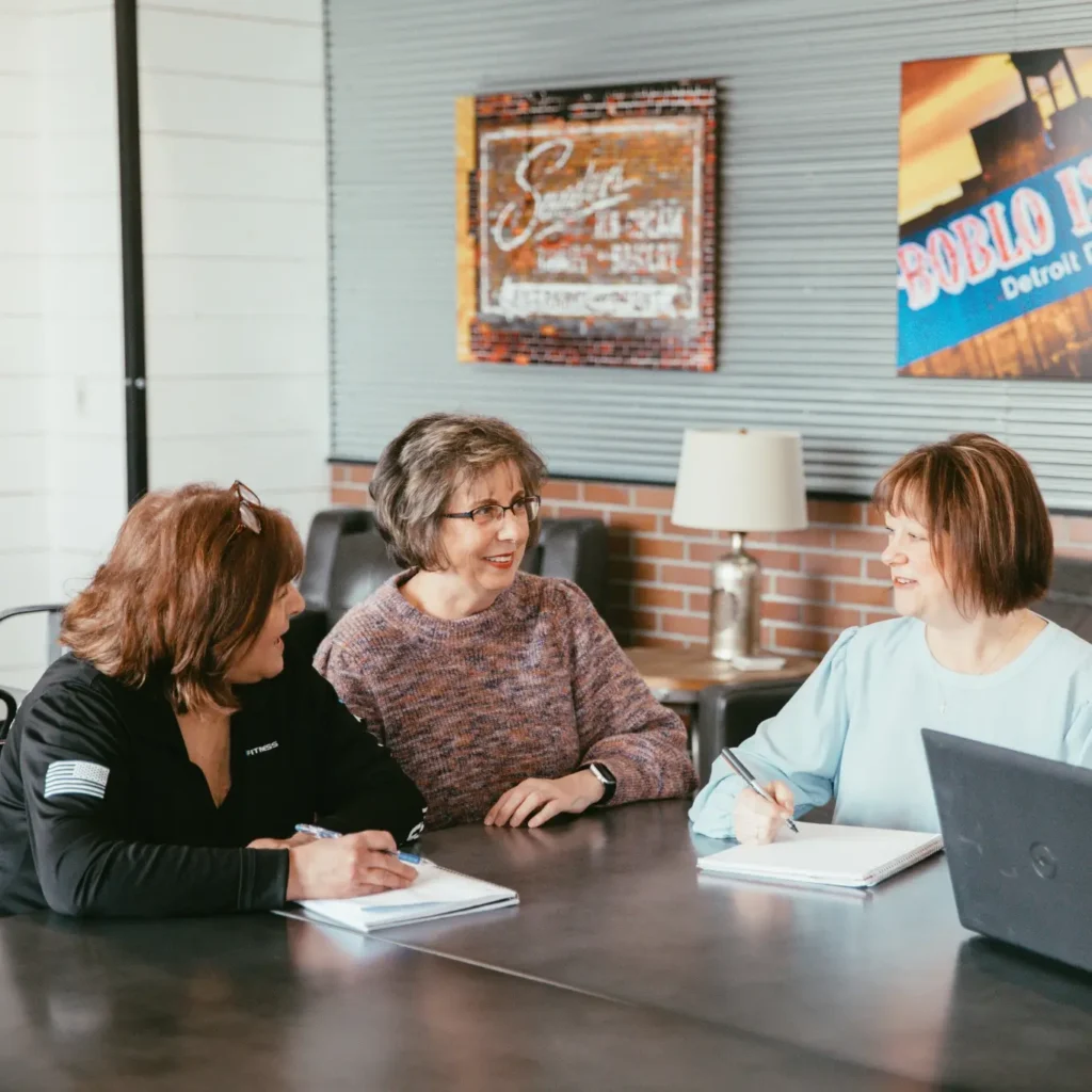 Members of the Michigan Planners team discuss policy options at a table in the office.