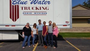 Members of the Michigan Planners team stand in front of a truck that reads, "Blue Water Trucking: Romeo, Michigan."