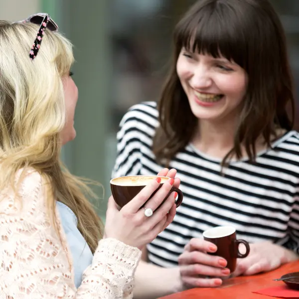 Two people laugh over coffee.