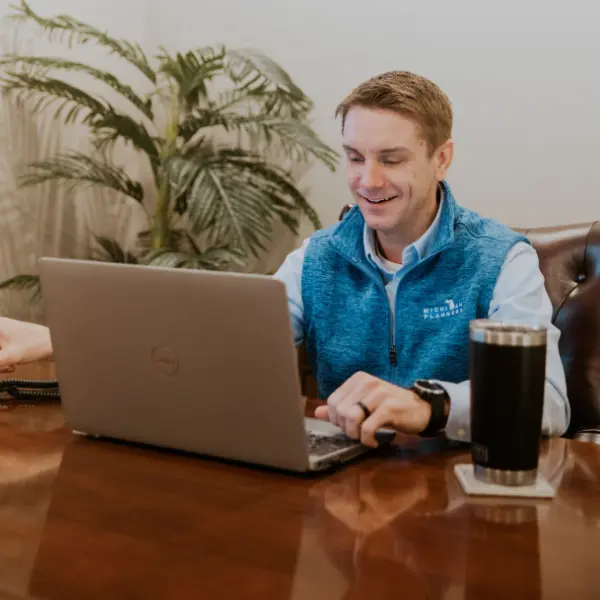 A member of the Michigan Planners team smiles while working on his laptop.