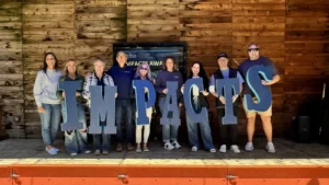Members of the Michigan Planners team hold up letters to spell IMPACTS.