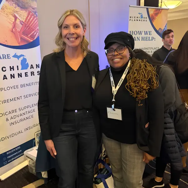A Michigan Planners team member smiles with a client at an industry event.