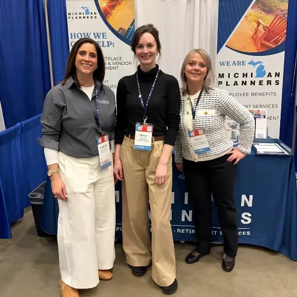 Three members of the Michigan Planners team pose for a photo at an industry event.